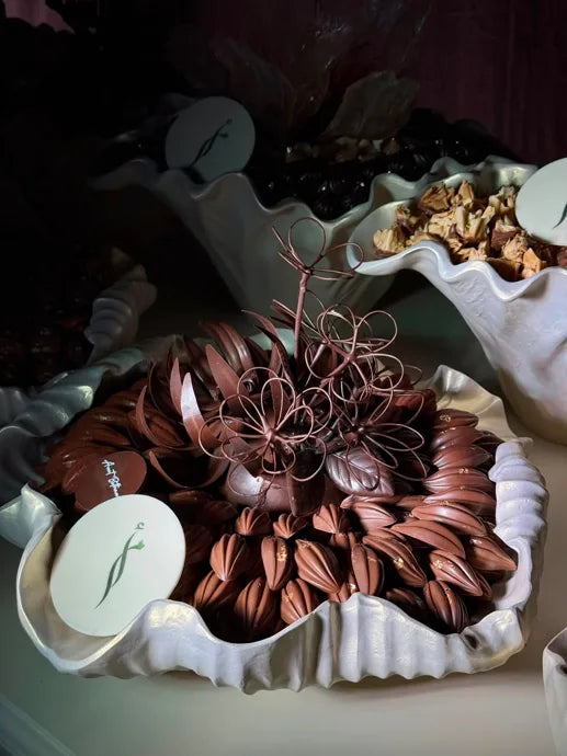 Dark chocolate floral sculpture displayed among assorted chocolates