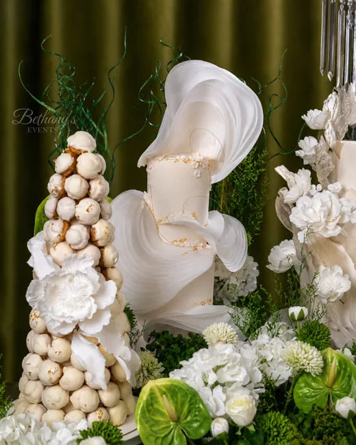 Sculptural ivory cake and white chocolate tower surrounded by flowers